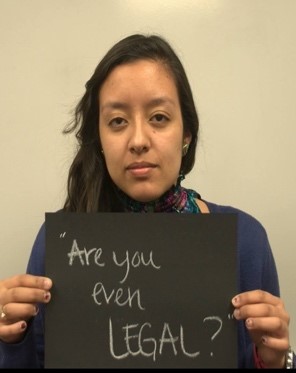 A person holds a sign reading "Are you even LEGAL?"